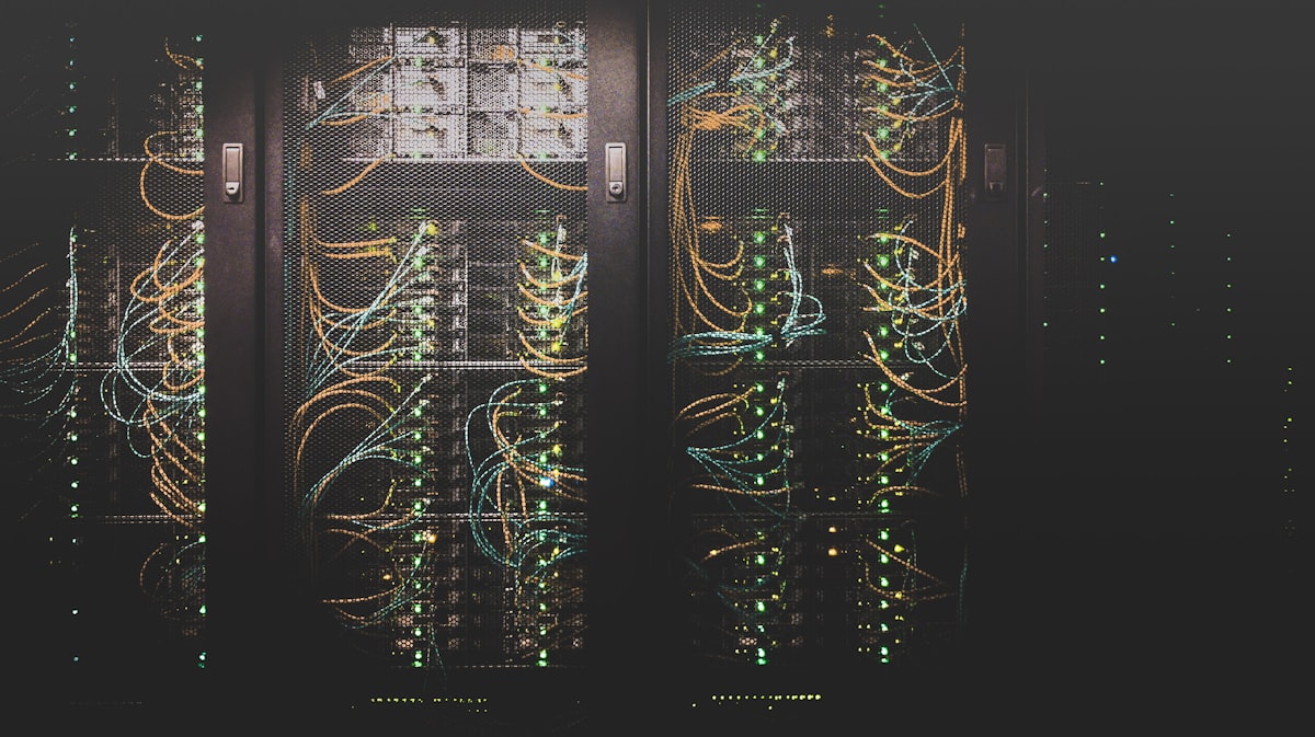 Dense server room with rows of illuminated servers and network cables creating intricate patterns of light